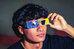 Senior Miguel Don Juan tests out "Solarbration" themed solar eclipse glasses in preparation for the upcoming solar eclipse on April 8. A total solar eclipse will pass through Texarkana for the first time in 375 years. 