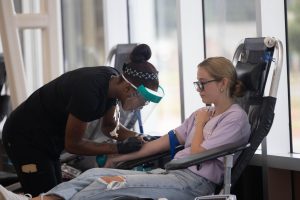 Junior Hadlee Sherman braces herself before her blood donation is drawn. Health Occupations Students of America club members assisted in the LifeShare Blood Drive at the Sullivan Performing Arts Center on Aug. 30, 2024. 