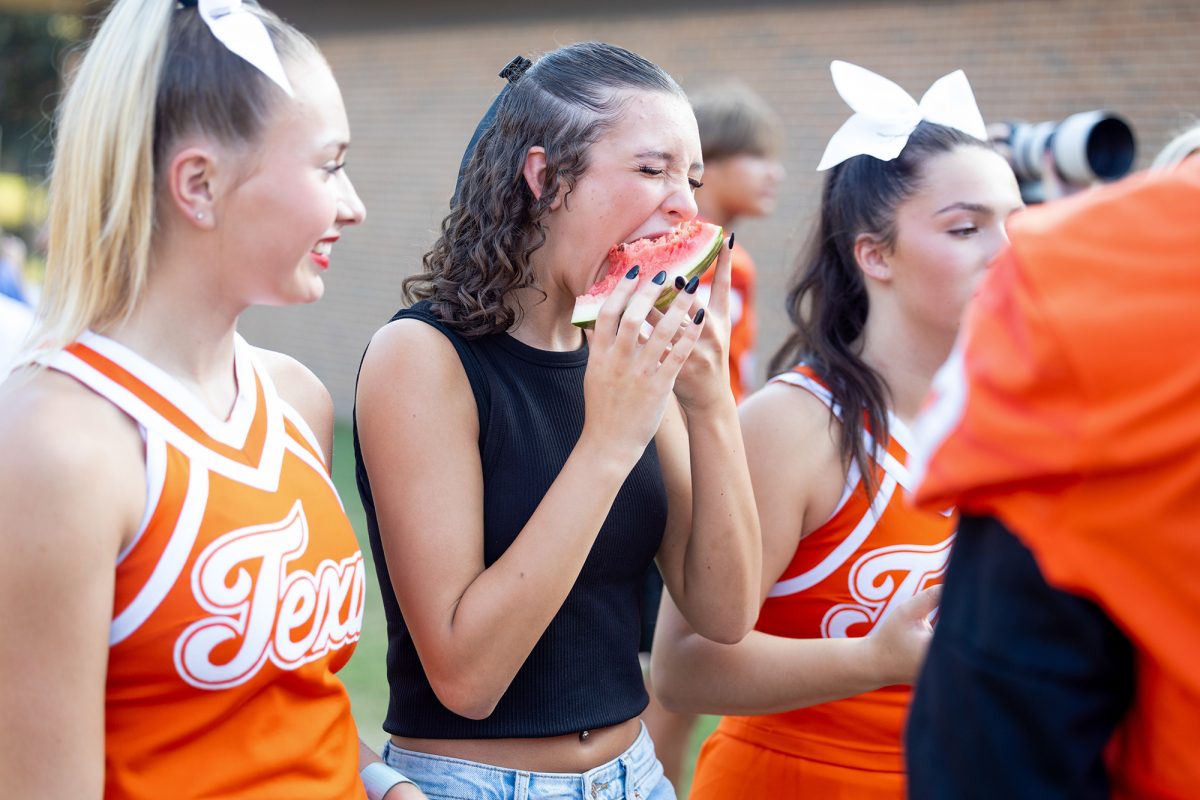 Sophomore Kylie Russet scrunches her face as she bites into a large slice of watermelon. Texas High's annual Watermelon Supper took place on Aug. 5, 2024 to kick off the new school year.