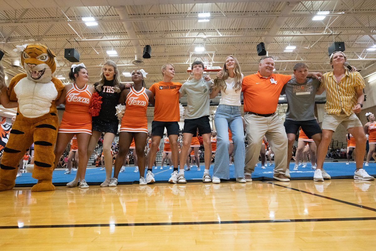 Members of Texas High's student council stand huddled together with Principal Ben Renner as they shout school chants. Following meet the teacher and Watermelon Supper was the first pep-rally of the school year. 