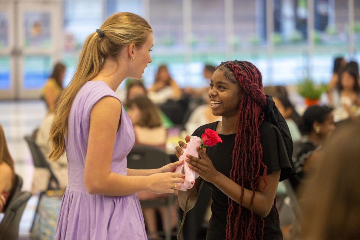 Sophomore Alexia Burton accepts her initiation rose as an incoming member of the Rosebuds Junior Garden Club. At the initiation dinner, held in the THS cafeteria, new and existing members discussed the club's plans and goals for the upcoming school year on Sept. 16, 2024. 