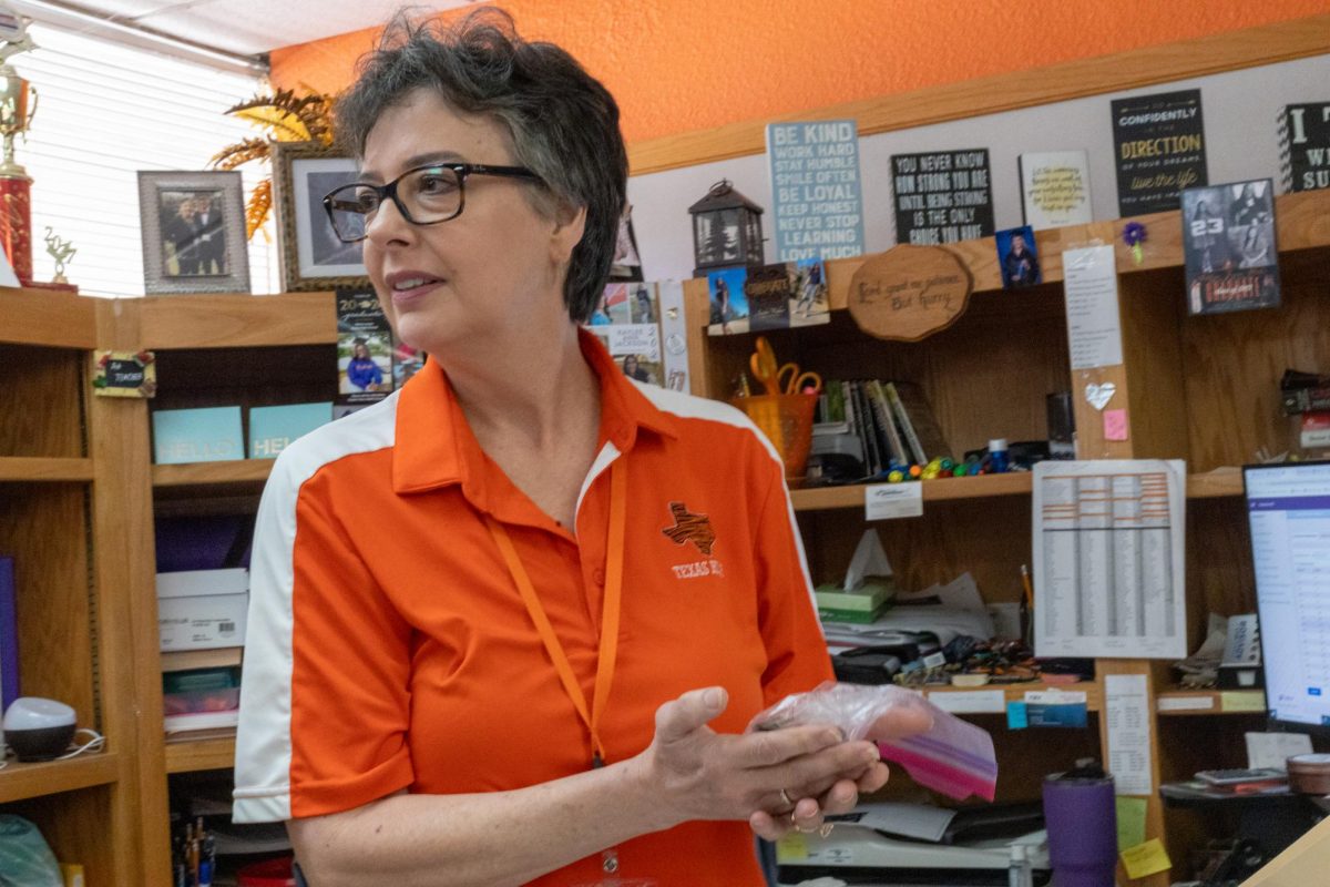 Career and technology teacher, Melinda Asher, expresses shock after receiving a bag of coins from one of her students in an attempt to postpone class. On Sept. 26, 2024 the Leader In Me organization held their first stall day to support their group's activities. 