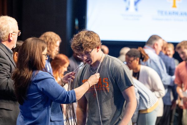 Texarkana College dual credit director Stephanie Stokes places a graduation regalia cord on the neck of Texas High School's Lincoln Horton at a ceremony honoring THS student with 15 or more college credit hours on Oct. 22, 2024 in the Sullivan Performing Arts Center.