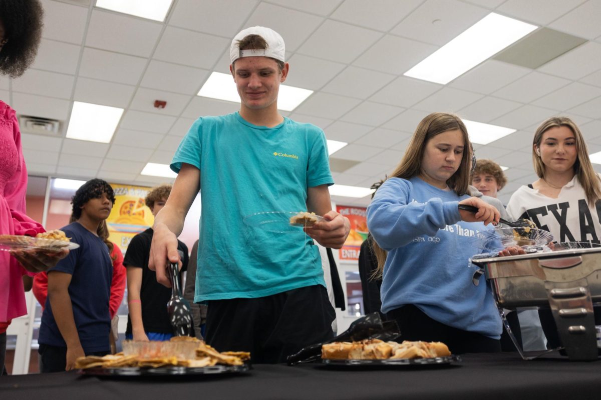 Reaching for a quesadilla, senior Max Likins fills his plate with potential options for new meals in the THS lunch lines. The district held a taste testing for students to give feedback and provide their opinions to the cooking staff on Oct. 29, 2024.