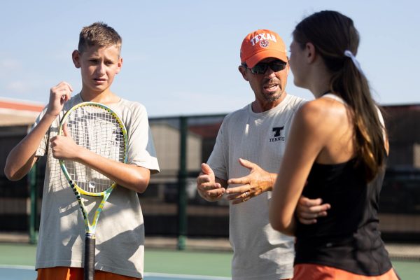 Coach Toby Watson talks strategy with varsity tennis players at the John Watson Tennis courts during the match against Pleasant Grove High School earlier this year.