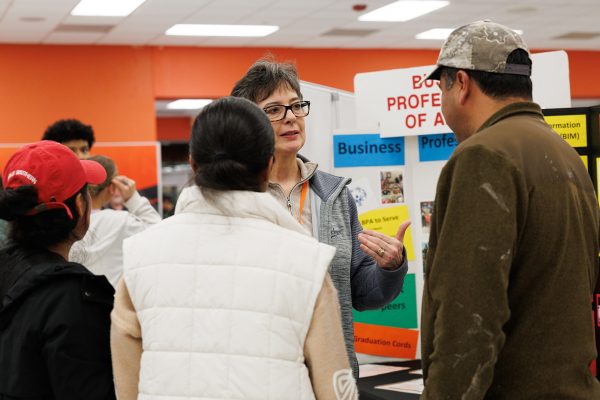 Business and information management teacher Melinda Asher speaks with parents and potential students at the Experience THS event on Jan. 27, 2025 in the Dan Haskins Student Center. The event allows parents and students the opportunity to meet with teachers, current students and future acedemic advisers at Texas High School to help prepare middle school students select courses for the 2025-2026 school year.