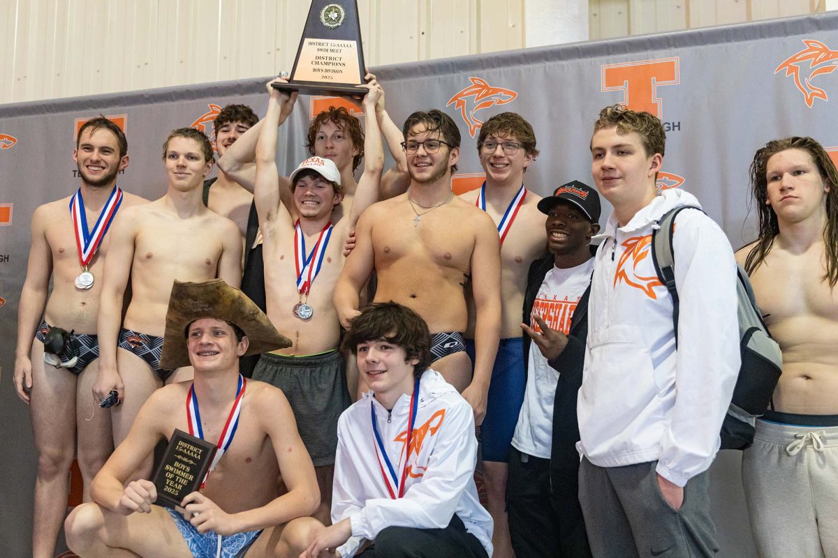 Junior Gunnar Taylor raises the boy's swim team district trophy after winning the entire meet on Feb. 3, 2025. Both boys and girls teams won their district meet with 24 out of the 26 swimmers advancing to regionals.