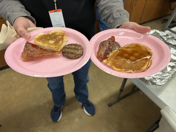 A CTE teacher holds two plates of breakfast made by the Future Farmers of America club. On Friday, Feb. 14, a Valentine's-themed breakfast was held in the agriculture parking lot from 7:30-11:20 a.m.
